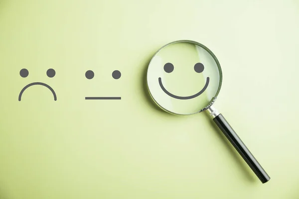 ガラスを拡大すると笑顔が現れ 悲しみの中で幸せを見つける サービス調査後の顧客満足度と評価 — ストック写真