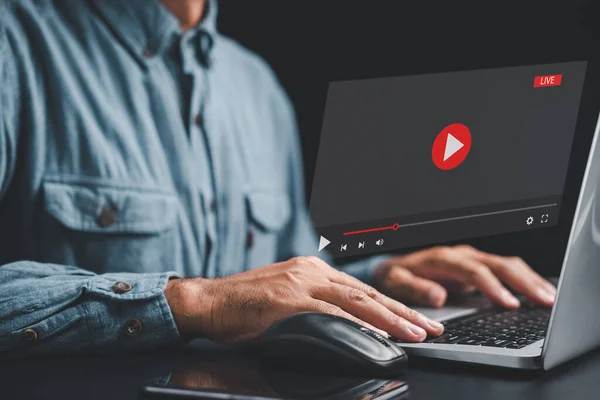 Man using a laptop to stream online videos and tutorials. Enjoy the convenience of streaming with just a mouse and keyboard. Explore a world of digital content at your fingertips.