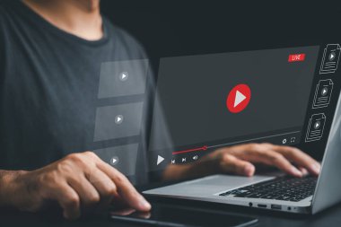 İşadamı bilgisayarındaki canlı yayından büyülenmiş. Bir multimedya oyuncusuyla çevrimiçi video yayınlama kavramı. Sanal olayların ve gerçek zamanlı içeriğin heyecanını yaşayın.