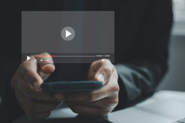 Akıllı telefonu canlı yayın için kullanan bir adam, çevrimiçi programlar, konserler, dijital ekranda özel dersler izliyor. Mobil aygıtı, teknolojisi ve sosyal medya platformlarıyla eş zamanlı video izleme