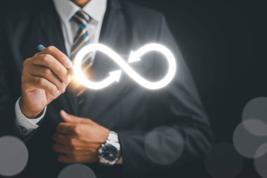 İş adamı veri teknolojisindeki sınırsız bağlantıyı temsil eden sonsuzluk sembolüne odaklanıyor. Siber uzay, gelecek sınırsız. Sonsuz güç, enerji, internet bilgileri. teknoloji sonsuzluk verisi