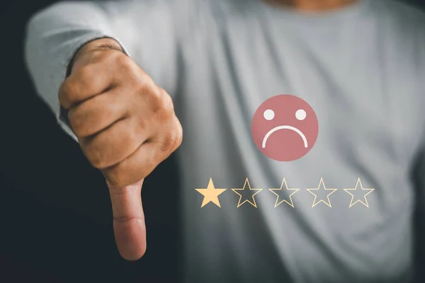 Hand showing a sign of low mark with thumb down and a graphic one star. Concept of dissatisfied customer experience, bad rating, negative review. Unhappy businessman client expressing sadness emotion.