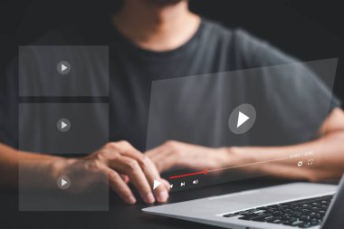 İşadamı dizüstü bilgisayarından canlı yayın seyretmeye dalmış. Ekranda multimedya oynatıcısı olan çevrimiçi video yayın kavramı. Teknoloji medyayı tüketme şeklimizi değiştiriyor.