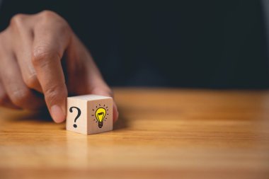 Yeni iş fikirleri ve strateji danışmanlığı. Ampul ikonlu ahşap blokla el ele tutuşmak. Dijital dönüşüm için yenilikçi çözümler. Başarı için yaratıcı beyin fırtınası ve uzmanlık.