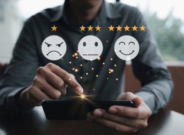 Akıllı telefondaki 5 yıldızlı geri bildirim ikonu ile müşterilerin elle değerlendirme servisinin yakın çekimleri. İş başarısı için çevrimiçi araştırma, inceleme ve tatmin kavramı