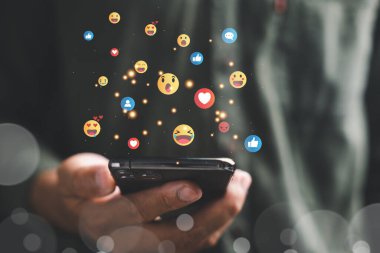 Sosyal medya iletişimi ve web bağlantısı. Elinde dijital afiş ve uygulama simgesi olan akıllı telefon tutan bir adam. Evden Sosyal Mesafe ve Çalışma