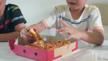 Mutlu Asyalı iki küçük çocuk 5 yıl boyunca evde birlikte büyük pizzalar yediler, çocuklar sağlıksız yemekler yediler, eğlenceli çocuklar pizza yediler, arkadaşlarıyla okul öncesi yemek yediler.