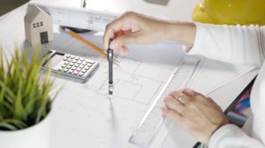 Mimari proje işyeri. Mimarlık bürosundaki masa masasında tamir aletleri için pusula üzerine pusula çizen mimar, inşaat projesi çizen mühendis.