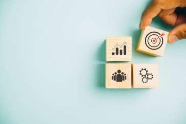 İş stratejisi ve eylem planı üzerine kurulu ahşap blokları mavi arka planda birleştirmek. İş geliştirme ve başarı hedefleme kavramının altını çiziyorum. Boşluğu kopyala