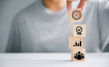 Elle, şirketin strateji gelişiminin önemini belirten bir simgeyle ahşap blok küpünü sunmak. Başarı ve iş hedeflerinin kavramsal görüntüsü.