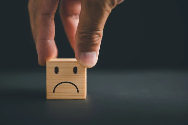 Customer Experience dissatisfied concept. Unhappy customer expressing dissatisfaction on a wooden block. Bad review, low rating, and negative feedback affect business reputation in online marketing.