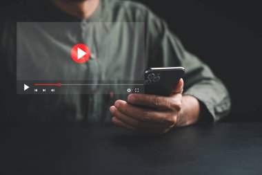 Genç bir adam çevrimiçi içerikle uğraşırken akıllı telefondan video izlemenin heyecanını yaşayın. Kendinizi filmler, gösteriler, dersler ve canlı performanslar dünyasına bırakın..