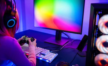 Kadınlar oyun kulaklığı takıyor evde canlı yayın esport oyun konsolu oynuyor, Oyuncular sanal turnuva oyunları için oyun kumandası kullanıyor bilgisayar neon ışıklarıyla çevrimiçi video oyunu oynuyorlar.
