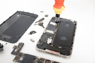 Technician repairing inside the smartphone motherboard with tools for recovery, The man repair by tightening nut from mobile phone with a screwdriver to fix problem