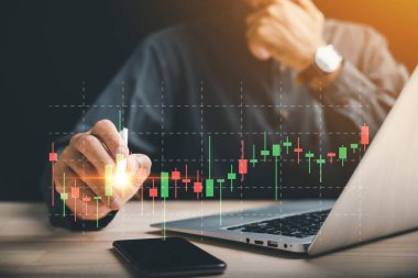 İşadamı dijital bir kalem tutuyor, akıllı bir telefonda sanal bir hisse senedine dokunuyor ve gösteriyor. İş büyümesi ve başarı için borsa konsepti. Stratejik planlama ile ticaret yapın.