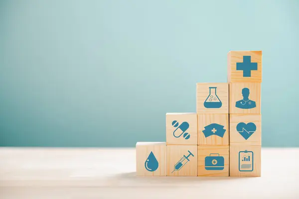 木制立方体呈金字塔形 说明了医疗保健和保险的概念 最上面的医疗保险标志着保护 健康保险主题为蓝色背景和版权空间 — 图库照片