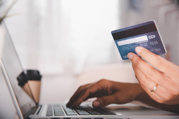 Online shopping. Woman hands holding credit card and using laptop with product purchase at home, female register via credit cards on computer to make electronic payment security online