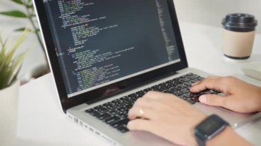 Programmer woman writing program HTML code sitting at workplace in office, IT software developer hands typing data coding programming with laptop computer, IT start up concept, Web application design