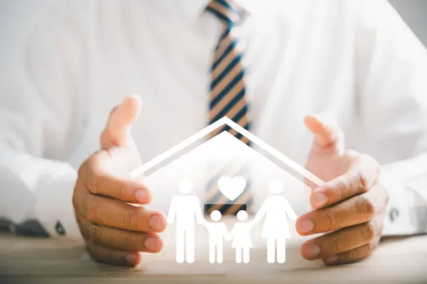 所描述的对家庭的保险支助 商人的保护姿态靠近年轻的家庭轮廓 健康和住房保险的图标 强调保险概念 — 图库照片