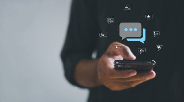 Akıllı telefon elinde olunca, adam canlı sohbete başlıyor, sosyal ağı kişileştiriyor ve sohbet kavramları geliştiriyor. Sohbet kutusunda, modern iletişim ve dijital bağlanmanın özünü sembolize ediyor..