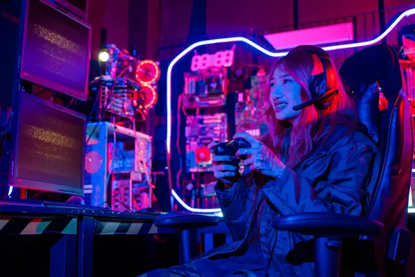 Young woman wear gaming headphones playing esports games console gaming room, Gamer using joystick controller for virtual tournament plays online video game with computer neon lights