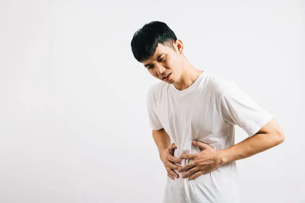 腹痛の若い男性の肖像画 胃の痛みや消化器系の問題を抱えています ホワイトバックで隔離されたスタジオ撮影 健康と医療上の懸念を強調 — ストック写真