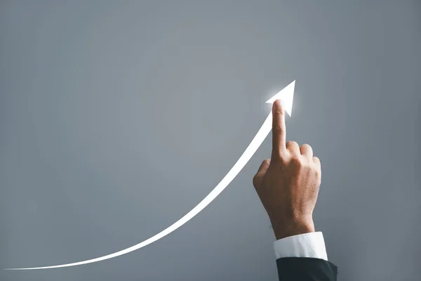A businessman pointing hand guides an arrow on a graph, illustrating the corporate future growth plan. the concept of business development, growth, and the journey to success.