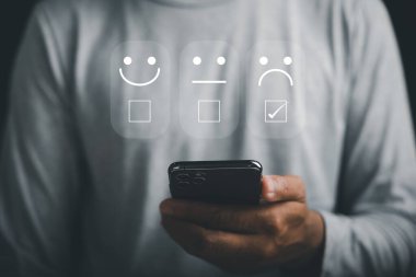 Olumsuz geri bildirim ve düşük reyting konsepti. Bir yıldız değerlendirmesi yapmak için akıllı telefonu kullanan kişi. Mutsuz müşteri tecrübesizliğini dile getiriyor. İşletme itibarına kötü puan