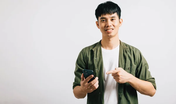 オンラインショッピングのためにスマートフォンを指差しながら 自信のあるアジア人男性の肖像画 スタジオは白で隔離され スマートテクノロジーの使用を強調した コピースペースが存在します — ストック写真