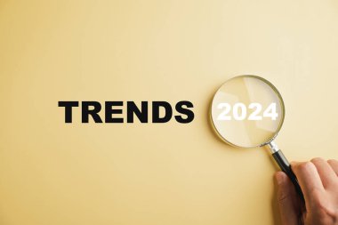 Büyüteç gözlükleri, başlıca değişim eğilimini vurgulayarak, 2024 yılındaki metni gösteriyor. Görüntü popüler ve ilgili konuları, iş dünyasındaki yeni eğilimleri ve değerlendirme yöntemlerini temsil etmektedir..
