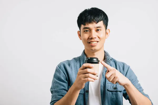 希望に満ちた若いアジア人男性が微笑み コーヒーカップを持ち 興奮を示しています コピースペースで白で隔離されたスタジオの肖像画 彼のポジティブな表現は優れている — ストック写真
