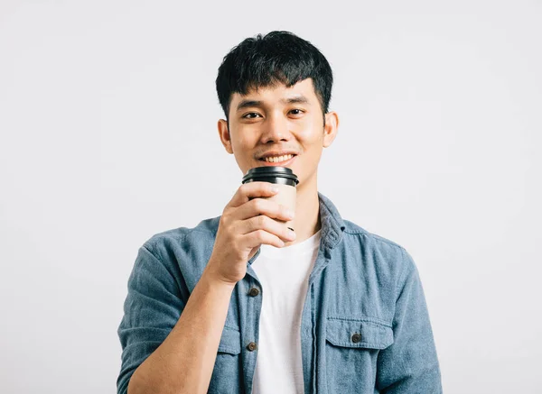 かわいい笑顔のハッピーな若いタイ人男性は テイクアウトのコーヒーカップを持っています コピースペースで白い背景に隔離されたスタジオの肖像画 笑顔の力 — ストック写真