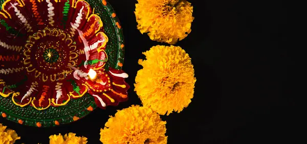 ディオワリランプと魅惑的な黒い背景にある複雑な花のレンジョリ お祝いの招待状や宗教的な儀式に最適 — ストック写真