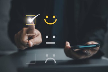 Mükemmel hizmet için olumlu geri bildirim sağlamak için akıllı telefon ve dizüstü bilgisayar kullanan bir adamın elini kapatın. İş tatmini anketi ve dijital teknoloji kavramı