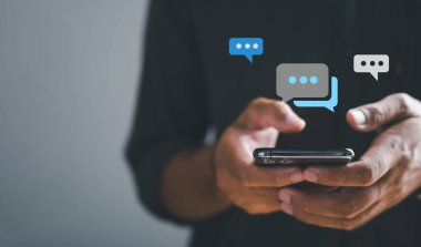 Adam akıllı telefondan hızlı bir şekilde yazı yazıyor, canlı yayında sohbet, sosyal ağın somut kavramları ve sohbetler. Sohbet kutusu simgeleri ortaya çıkıyor, sosyal arabuluculuğun teknolojiye dayalı doğasını özetliyor.