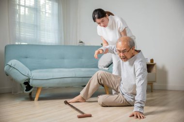 Asyalı yaşlı bir adam bastonla yere düştü ve torun kampı oturma odasında geçimini sağlamak için, genç bir kadın yere düştükten sonra büyükbabasını yaraladı, baş dönmesi