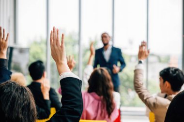 Kurumsal bir etkinlikteki konferans ve kongrede iş adamları soru sormak ve oy vermek için ellerini kaldırdılar. Toplantı eğitim semineri ve tartışmalarda takım çalışması ve işbirliği vurgulandı.