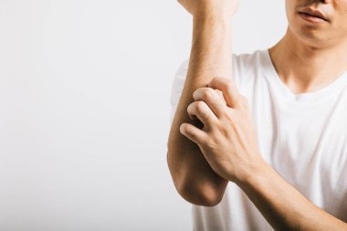 Kolunu kaşıyan mutsuz bir adamın portresi. Sivrisinek ısırığından kaynaklanan kaşıntılarla uğraşıyor. Stüdyo çekimi beyazdan izole edilmiş, deri iltihabı ve uyuz gibi deriyle ilgili sağlık sorunlarını vurguluyor..