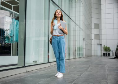 Bir alışveriş merkezinde alışveriş yaparken birden fazla işi laptoplar ve bardaklarla yapan bir grup kadın, modern çalışan kadını temsil ediyor..