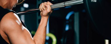 Kaslı vücutlu çekici bir erkek halterci spor salonunda ağırlık geliştirmek için halter kaldırıyor. Güç kaldırma eğitim kavramı