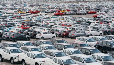 Lamchabang, Tayland - 2 Temmuz 2023 Güneşli bir araba fabrikasında, bir dağıtım merkezi yeni arabalara ev sahipliği yapıyor. En tepede modern sanayi ve pazarlamanın hareketli park simgesi sergileniyor.