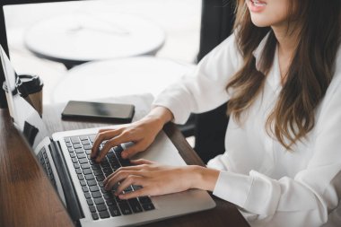İnternet sayfası yazmak için dizüstü bilgisayara klavye yazan mutlu güzel serbest yazar, Asyalı genç iş kadını yaşam tarzı kafede dizüstü bilgisayarla oturuyor.