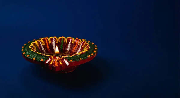 Celebrate Diwali with these radiant clay diya lamps, representing prosperity and happiness, illuminating the night against a blue background. Perfect for festive invitations, greeting cards