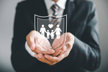 Aile değerlerini koruyan iş adamı koruyucu jesti genç aile siluetini tamamlıyor. Sağlık ve ev sigortası ikonları, aile desteğini vurgulayarak korumayı sembolize eder. Aile hayat sigortası