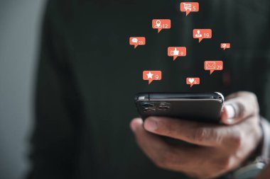 Sosyal medya ve iletişim arasındaki dinamik bağlantı canlı sohbet yazmak için akıllı telefonunu kullanmasıyla ortaya çıkıyor. Sohbet kutusu simgeleri sosyal ağın dijital özünü ve sohbet kavramlarını sembolize eder.