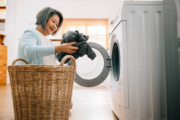 Eine Fröhliche Seniorin Eine Lächelnde Großmutter Lädt Schmutzige Wäsche Die — Stockfoto