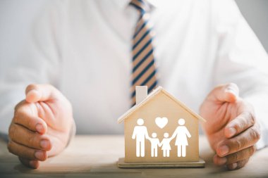 Aileler için güvenlik ve güvence. Aile siluetinin yanında iş adamı koruyucu jesti. Aile, yaşam, sağlık ve ev sigortası ikonları. Sigorta konsepti iletiliyor.