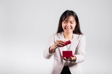 Gülümseyen kadın özgüveni, avuç içi izole edilmiş beyaz arka planda kırmızı bir hediye kutusu açıyor, sürpriz doğum günü veya Noel günü ve sevgililer günü, Asyalı mutlu portre güzel genç bayan stüdyo resmi, kopyalama alanı