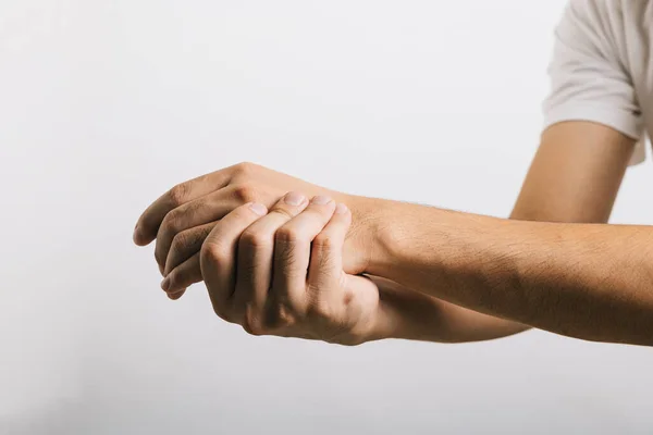一个悲伤的亚洲男人 他的腕部疼痛 可能是由于腕管综合症 反映了手臂不适的挑战 因白色而被隔离的工作室拍摄 说明保健和医疗问题 — 图库照片