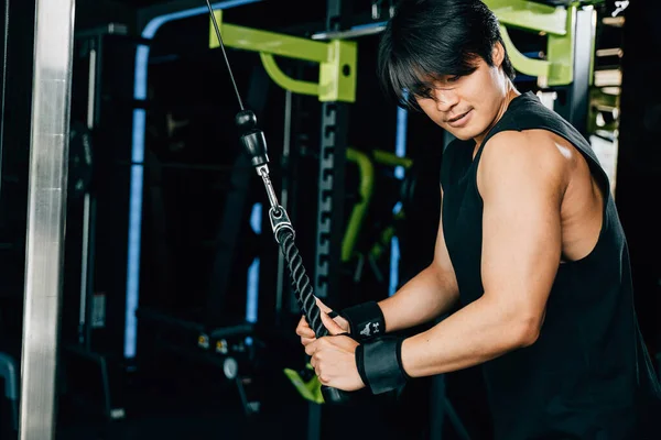 Muscular Young Man Exercising Pull Cable Machine Targeting His Triceps — Stock Photo, Image